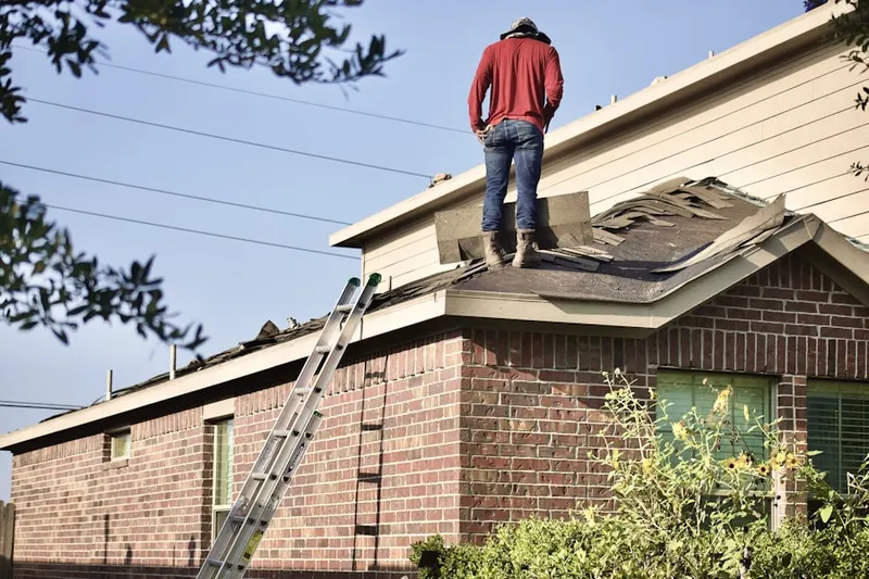 Professional roofer working on a residential roof in Chestnut Hill
